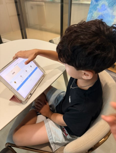 느린아이 앱으로 거스름돈 만들기 연습 중인 아이